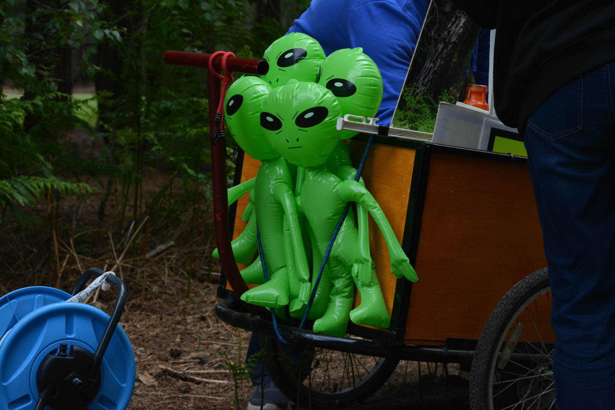 A group of inflatable aliens being transported in a trolley through Rendlesham Forest